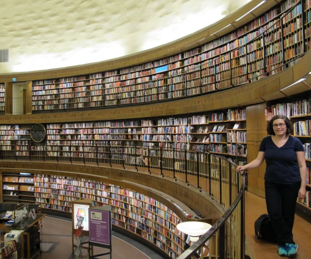 Allison standing in front of the curving bookshelves in the Stockholm public library